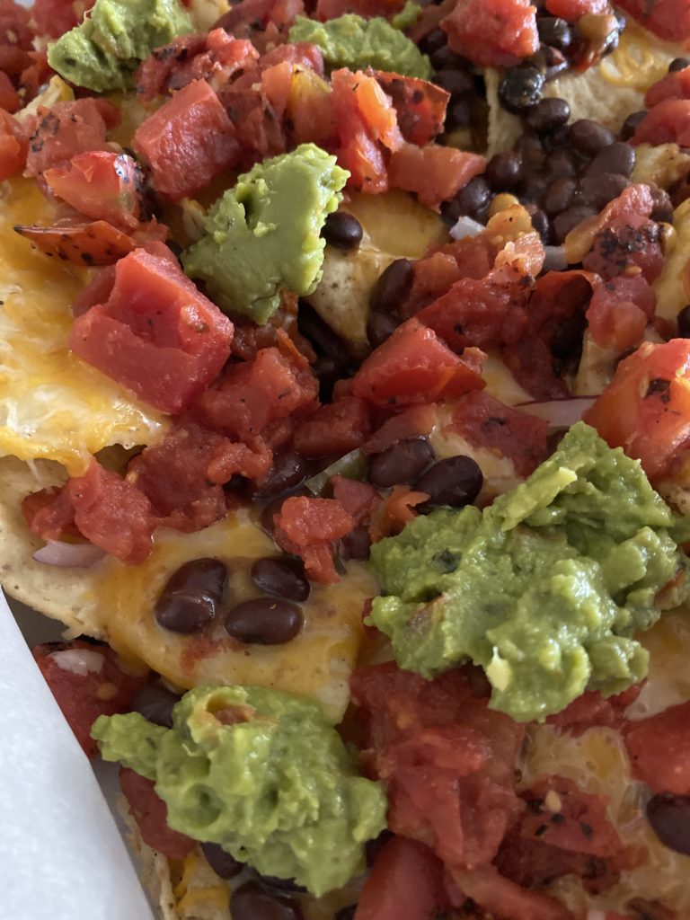 nachos with beans, tomatoes, and guac