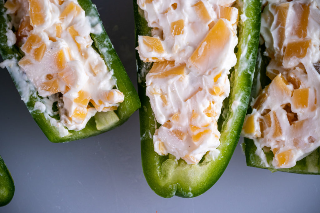 uncooked jalapenos stuffed with cream cheese and cheddar cubes