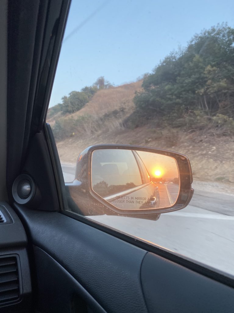 reflection of sunset in the rearview mirror